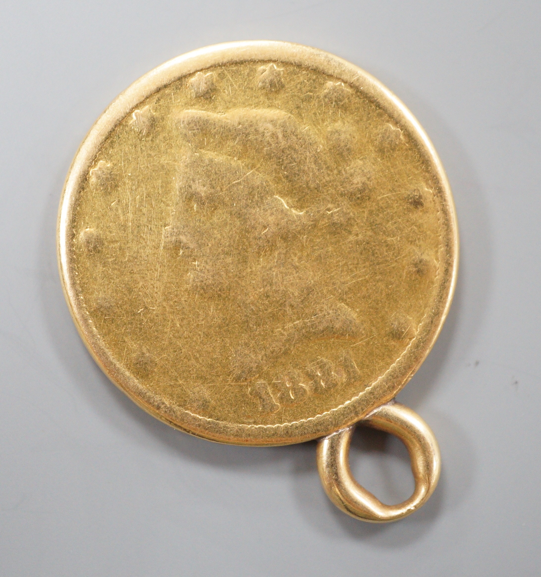 A worn gold dollar coin, now mounted as a pendant, 16.4 grams.